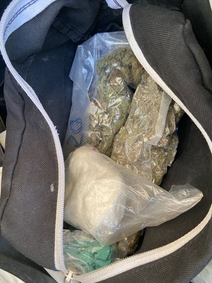 Zdjęcie przedstawia narkotyki zabezpieczone podczas interwencji policjantów u młodego 31-letniego mężczyzny tj. marihuanę, amfetaminę i tabletki ekstazy. Na zdjęciu widać narkotyki spakowane w torbę, która została wyrzucona przez okno przez 31-latka