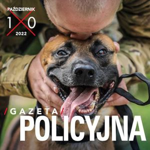 Zdjęcie stanowi czołówkę Gazety Policyjnej na miesiąc Październik 2022 r. Na zdjęciu widać przewodnika stojącego nad psem i dotykającego swoim czołem głowy psa służbowego.