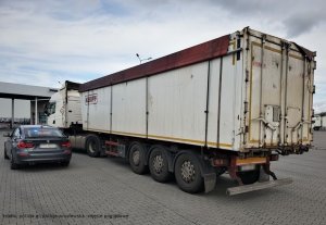Zdjęcie przedstawia samochód ciężarowy z naczepą a obok niego radiowóz nieoznakowany marki BMW - jest to zdjęcie poglądowe nie związane z opisanym w artykule zdarzeniem