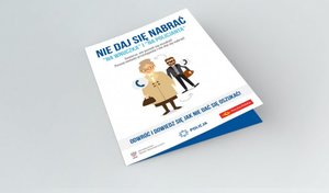 Zdjęcie poglądowe przedstawia broszurę informacyjną z informacją o przestrodze dotyczącej oszustw na wnuczka i policjata